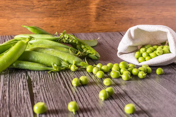 Guisantes en una mesa de madera —  Fotos de Stock