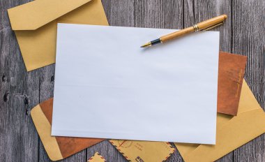 Kalem ve bir ahşap masa zarflara ile mektup