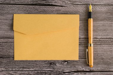 Kalem ve bir ahşap masa zarflara ile mektup