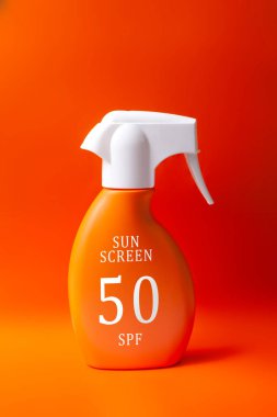 Turuncu arka planda güneş kremi. yaz bakımı konsepti.