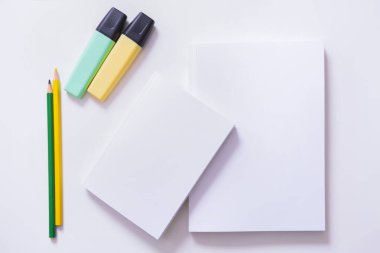 Renkli kalemleri ve boş defterleri olan bir masanın üst görüntüsü. Boşluğu kopyala.