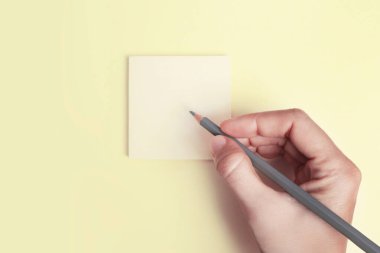 Gri kalemle boş sarı notaya el yazısı