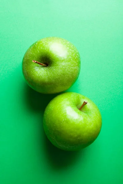 緑の背景に緑のりんごが2つ — ストック写真