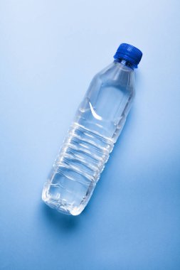 Mavi arka planda izole edilmiş plastik su şişesi. Temel kavram geri dönüşümü.