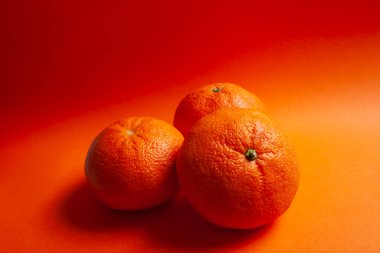 Turuncu arka planda 3 portakal izole edilmiş. Organik yiyecekler.