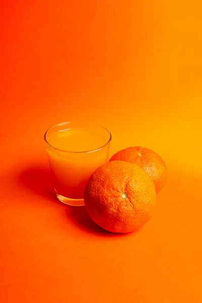 orange juice with oranges on orange background. Healthy drink concept.