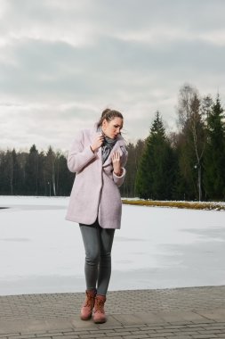 Dondurucu kız kış ormandaki göl yakınındaki pembe ceket