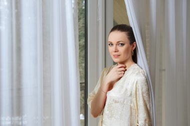 pencere curtai arkasında yakınındaki ipek sabahlığı genç ve güzel kadın