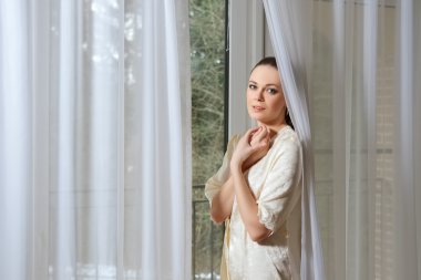 pencere curtai arkasında yakınındaki ipek sabahlığı genç ve güzel kadın
