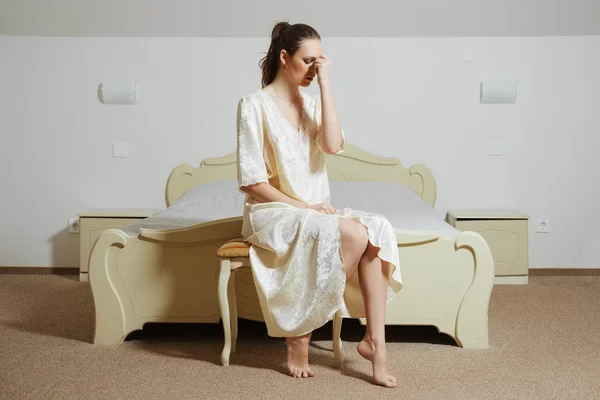 Bela jovem senhora no quarto em seda peignoir perto da cama — Fotografia de Stock