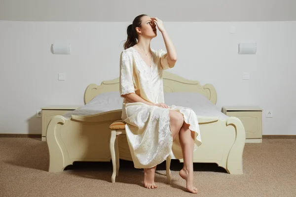 Bela jovem senhora no quarto em seda peignoir tocando sua cabeça — Fotografia de Stock