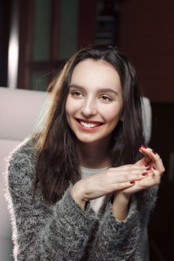 elleri onun çene, gülümseyen ve hasebiyle yakın oturan güzel kız