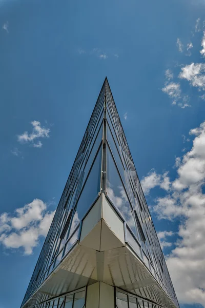 Edifício de vidro triângulo com reflexo de nuvens nas janelas — Fotografia de Stock