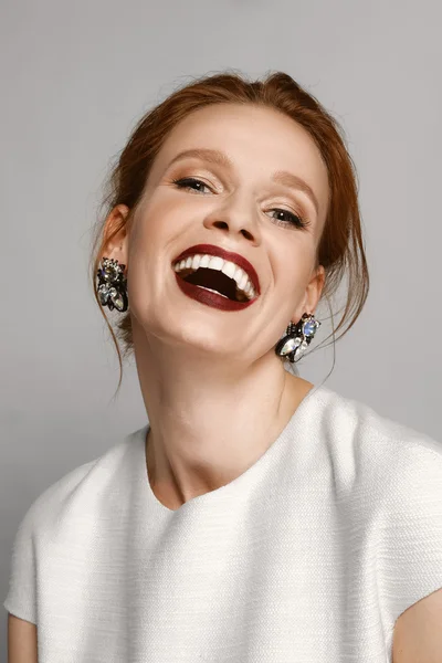 Modelo de risa con labios de alfombra roja y pendientes de piedras preciosas — Foto de Stock