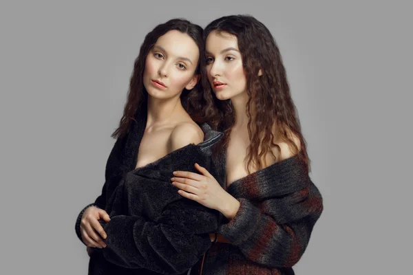 Dvě mladé módní andělé v eco kůže, kabát pózuje — Stock fotografie