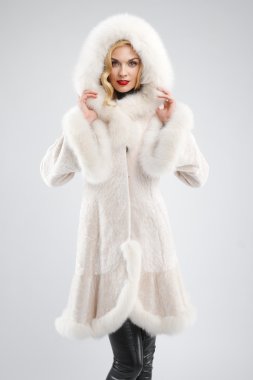 Beyaz kürk manto ile başını kaputa çekici Bayan
