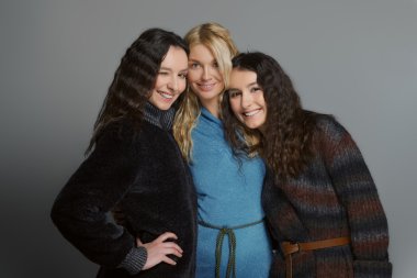 Mutlu gülümseyen arkadaşlar. Yün kat olarak üç çekici kızlar.