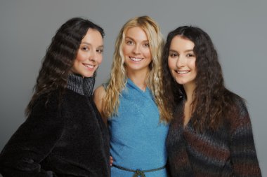 Mutlu gülümseyen arkadaşlar. Yün kat olarak üç çekici kızlar.