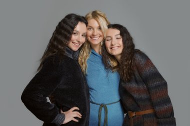 Mutlu gülümseyen arkadaşlar. Yün kat olarak üç çekici kızlar.