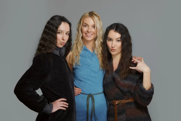 Felizes amigos sorridentes. Três meninas atraentes em casacos de lã . — Fotografia de Stock