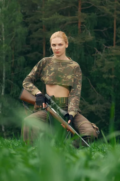 Atractiva chica cazadora con carabina de caza mirando hacia el trop — Foto de Stock