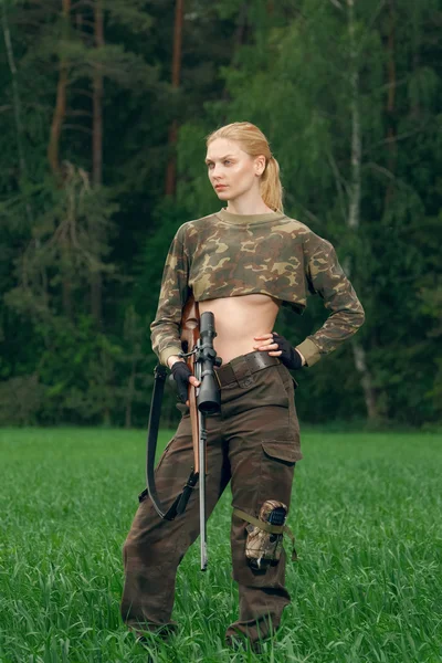 Attraktives Jägermädchen mit Jagdkarabiner, das aus der Trop schaut — Stockfoto