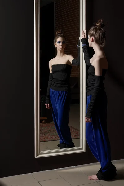 Modelo muito jovem em calças de moda e top de lã perto espelho de parede — Fotografia de Stock