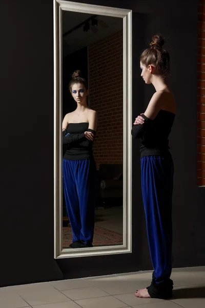 Modelo muito jovem em calças de moda e top de lã perto espelho de parede — Fotografia de Stock
