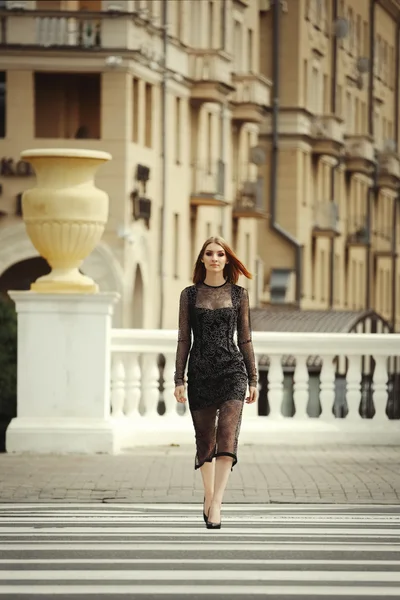 Attraente ragazza in abito nero che attraversa la strada — Foto Stock