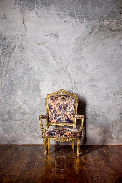 Retro armchair on wooden floor near grey wall — Stock Photo, Image