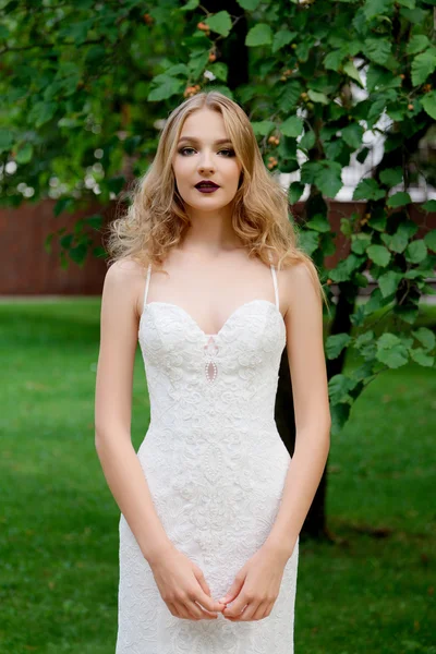 Ritratto di una bella sposa di moda in parco. Trucco nuziale e capelli . — Foto Stock