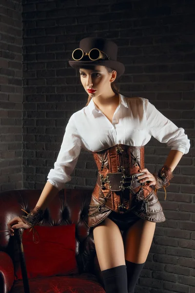 Nahaufnahme Porträt eines schönen Steampunk-Mädchens in Dessous und Strümpfen, das in der Nähe eines alten Sessels steht. — Stockfoto