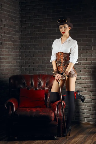 Portret van een mooie Steampunk meisje in lingerie en kousen, muts en bril. — Stockfoto