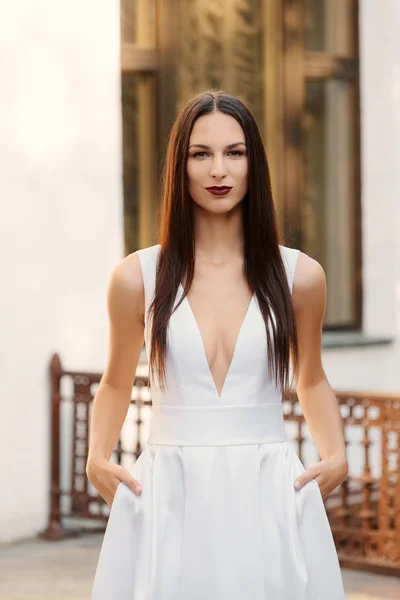 Menina bonita em vestido branco longo com um decote profundo. Moda — Fotografia de Stock