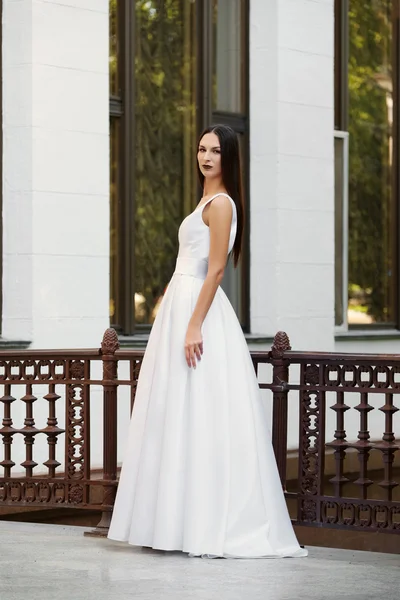 Beautiful girl in long white dress with a deep neckline. Fashion