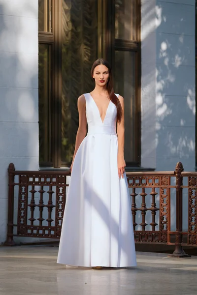 Menina bonita em vestido branco longo com um decote profundo. Moda — Fotografia de Stock