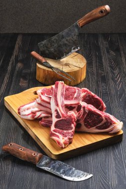 Çiğ kuzu pirzola, tahta kesme tahtasında.