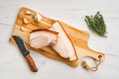 Ahşap kesme tahtasının üzerinde soğuk füme domuz göbeği manzarası