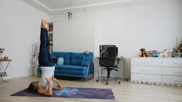 Ung Kvinna Stöttar Axelställning Yoga Poserar Hemma — Stockvideo