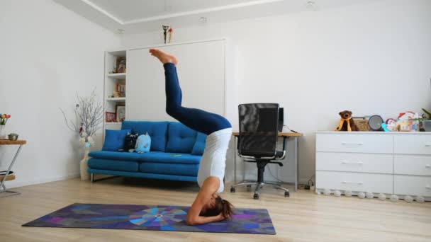 Ung Kvinna Utövar Yoga Hemma Står Stödd Huvudstöd — Stockvideo