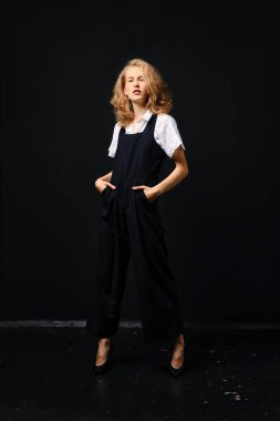 Siyah takım elbiseli, beyaz gömlekli, siyah arka planda güzel bir manken.