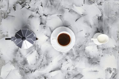 Gayzsr kahve makinesinin üst görünümü, soyut arka planda sütlü fincan ve demlik