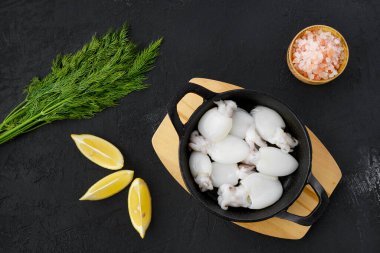 Dökme demir tavada, dereotlu, tuzlu ve limonlu yavru mürekkep balığı manzarası