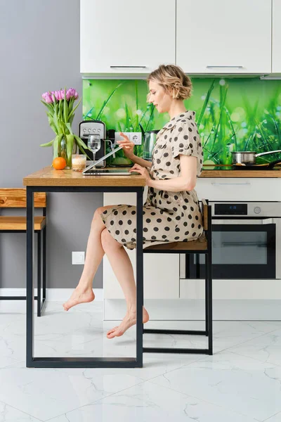 Serious young woman starts working day at home office, she is opening cover of her laptop