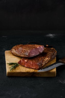 Kesme tahtasının üzerinde tütsülenmiş sığır eti.