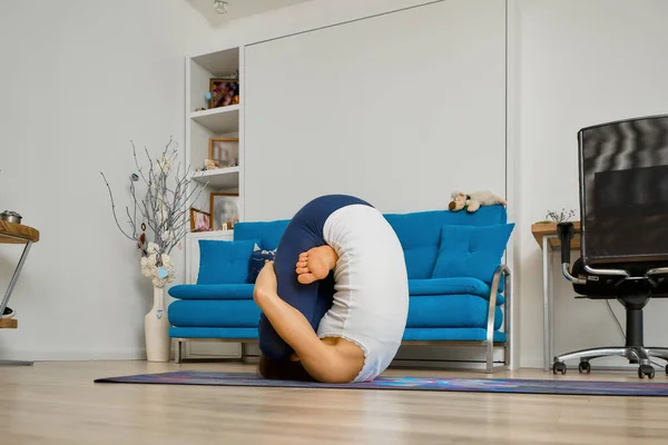 Chica Hace Yoga Casa Doblando Rodillas Pecho Pose Pindasana —  Fotos de Stock