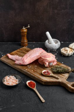 Ahşap kesme tahtasının üzerinde çiğ hindi kanadı