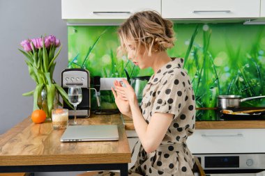 Ciddi genç bir kadın, iş yerinde işe başlıyor. Dizüstü bilgisayarının kapağını açıyor.