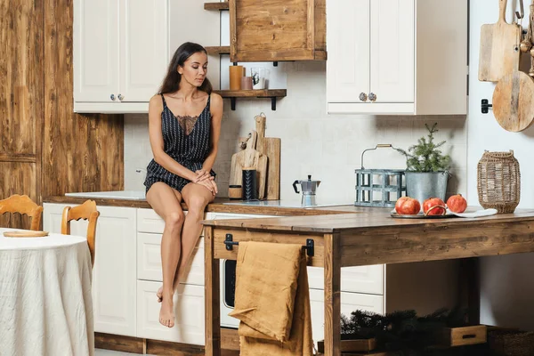 Schöne Junge Frau Sitzt Auf Küchentisch Und Schaut Wie Kaffee — Stockfoto