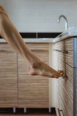 Çıplak kadın bacağı mutfak masasının üstüne dayanır (yumuşak odak fotoğrafı)